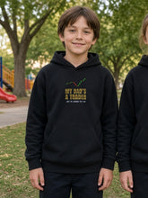 Load image into Gallery viewer, Kids My Dad's A Trader Hoodie in black worn by a boy in a park